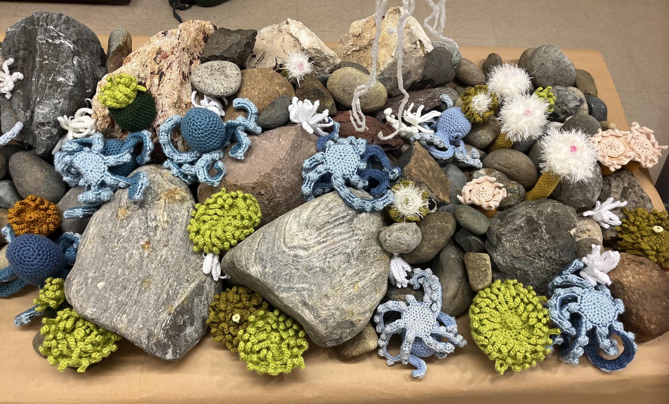 A table with crocheted marine life and rocks