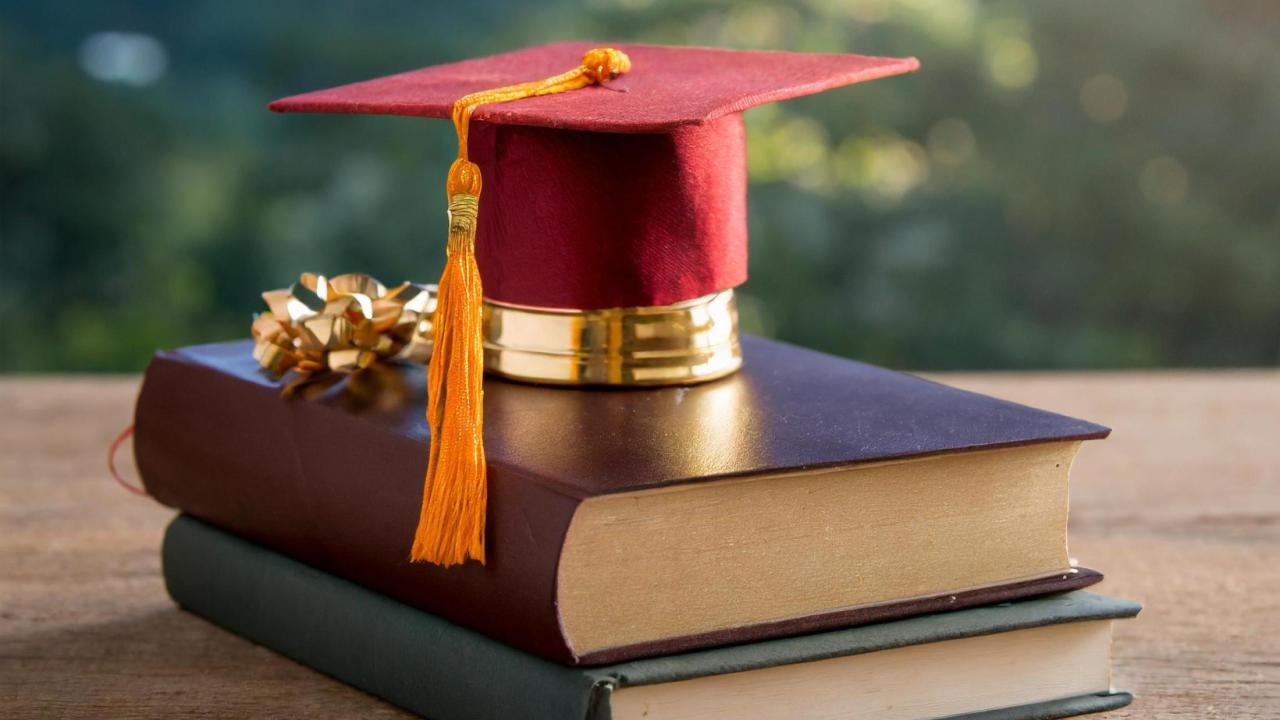 A graduation cap on top of books